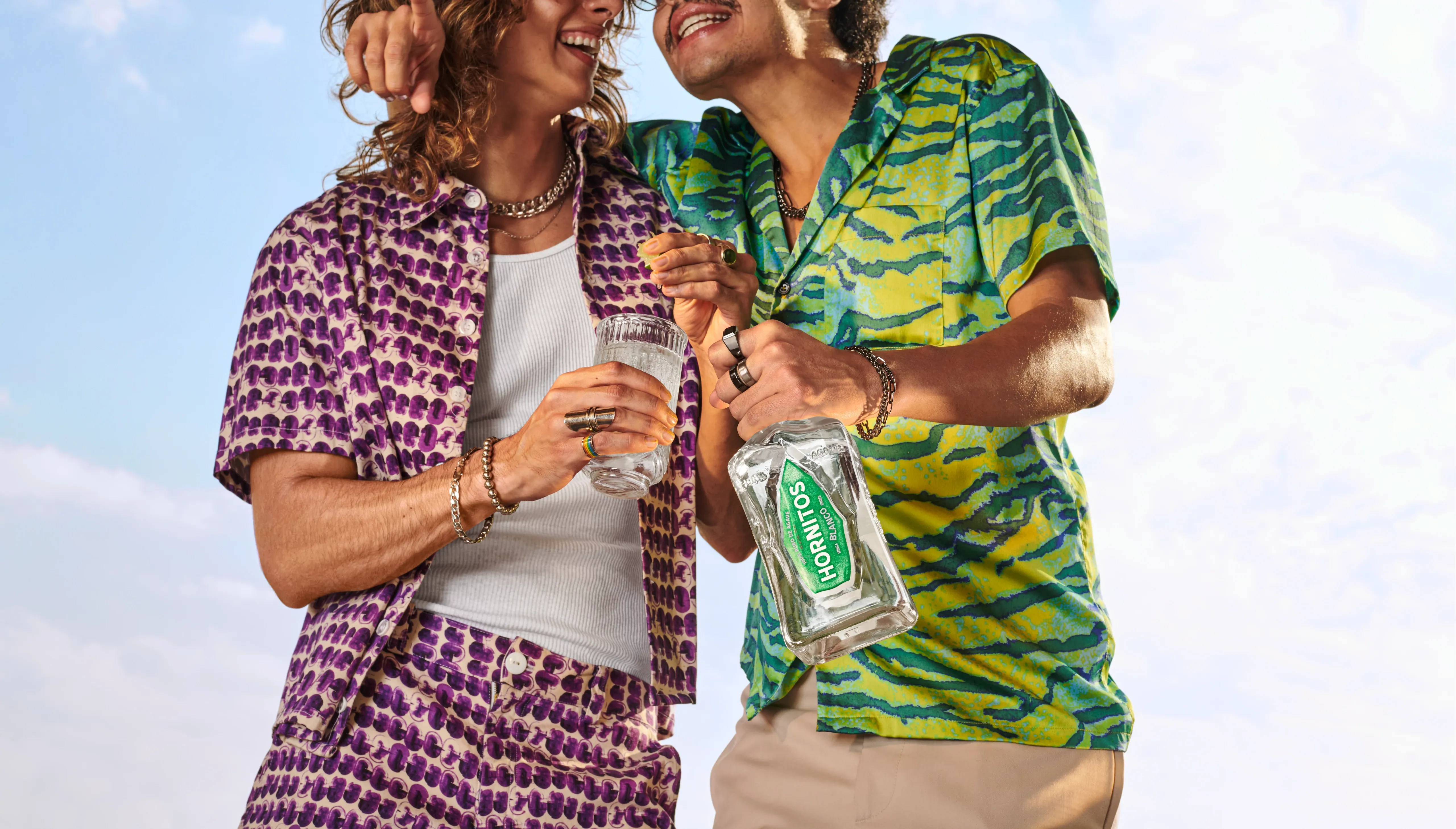 Friends enjoying drinks outdoors with Hornitos® Blanco tequila, pouring cocktails on a sunny day