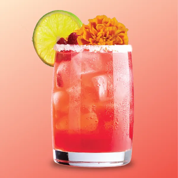 A vibrant red cocktail garnished with a slice of lime, marigold flower, and raspberries, served in a chilled glass with ice.